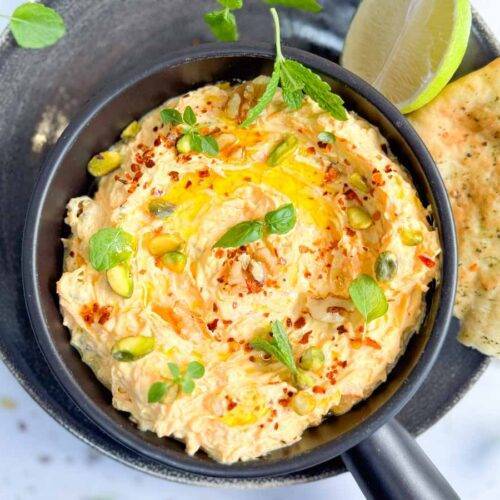 top view of bowl with Havuçlu Tarator with herbs and Turkish bread