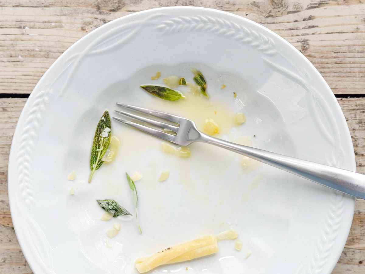 empty plate with sage and pasta rests